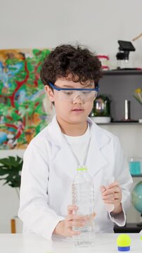 Young Boy in Lab Coat Performing Bernoulli's Principle Science Experiment