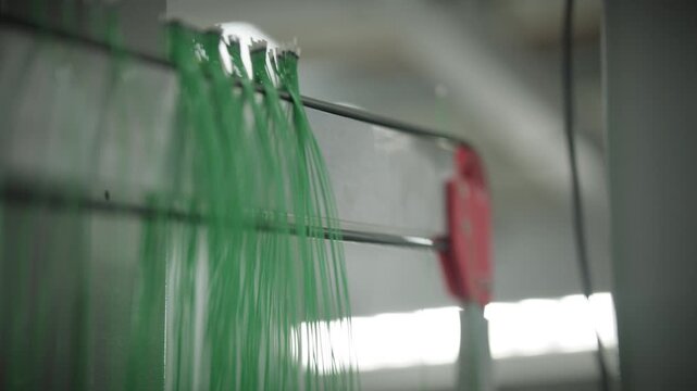 Automated robot hangs finished temperature sensor cables onto a storage rack