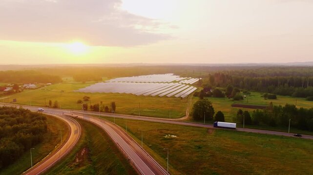 Golden morning light over solar panels beside highway in Latvian countryside