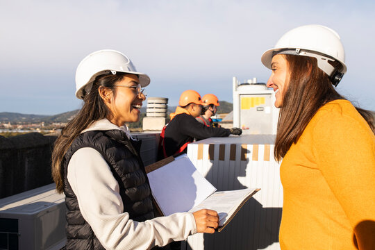 Engineers and site managers discussing at solar panel construction site outdoors