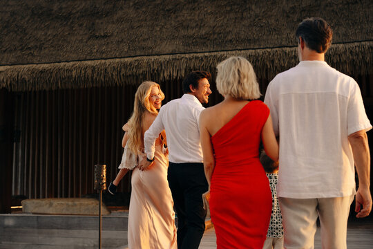 Group of friends walking to luxury resort restaurant for fine dining