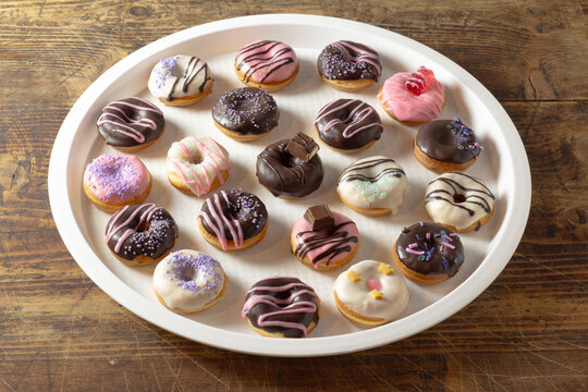 Mini donuts covered in chocolate on a white background.