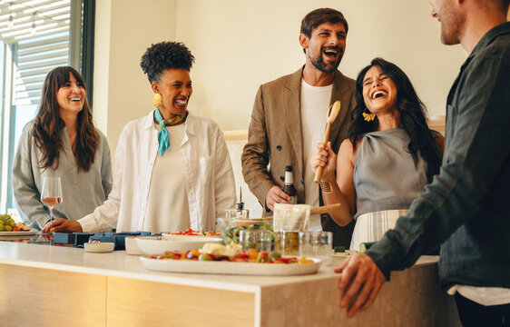 Friends sharing laughter and joy during a home dinner party gathering