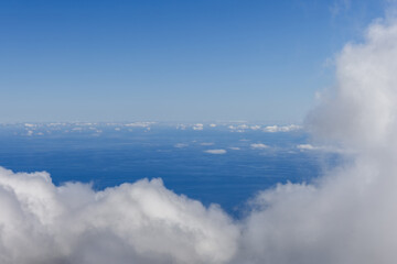 Obraz premium Ocean horizon above clouds under blue sky, high altitude view with soft mist and wide copy space for text overlay ideal as calm background for creative design