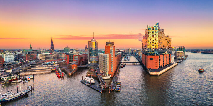 Aerial panoramic sunset view of the Elbphilharmonie building in Hamburg, Germany with ships in the harbor and the Elbe river