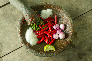 Fresh Ingredients in a Traditional Stone Mortar for Authentic Spices and Flavors