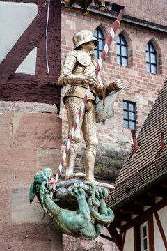 View of a golden knight statue standing triumphantly over a defeated green dragon, an emblem of history, Nuremberg, Bavaria, Germany.