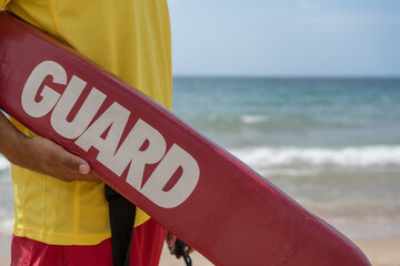 Lifeguard holding rescue buoy on a beach