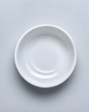 Empty white porcelain sauce dish isolated on light gray background with left copy space