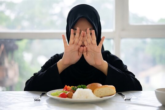 Young Woman Showing Stop Hand Gesture with Food on Table (2)  buka puasa