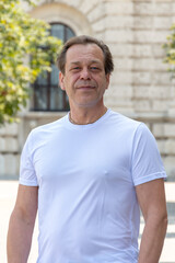 Obraz premium Portrait of European man outdoors in city center during summer day.