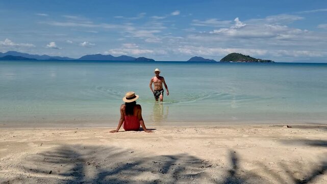 Enjoy the serene beauty of Koh Mak in Trat, Thailand, where gentle waves lap at the shore and lush mountains frame the horizon. A perfect spot for relaxation and exploration.