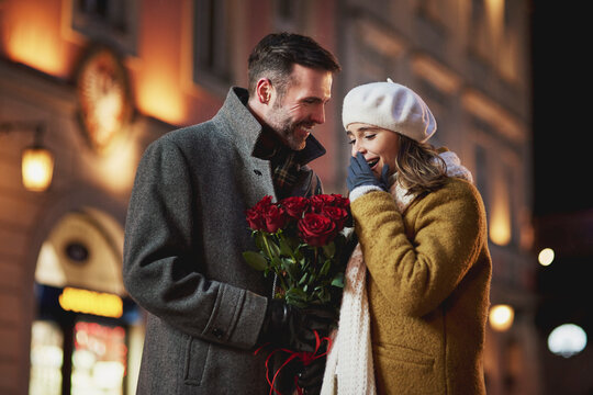 Man giving his girlfriend bunch of red roses on Valentine's Day