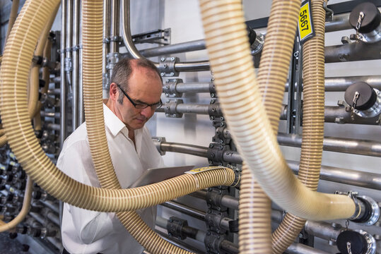 Man with tablet examining the system in factory