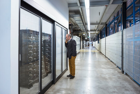 Businessman in factory shop floor talking on the phone