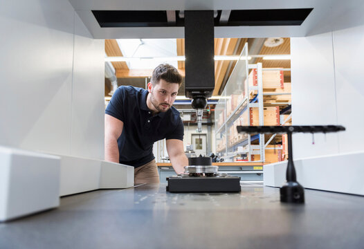 Man examining machine in modern factory
