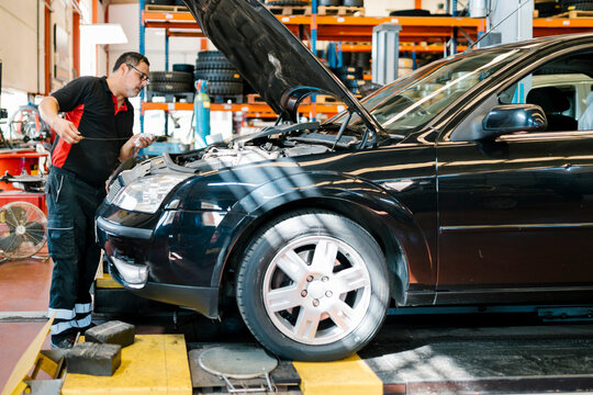 Male mechanic repairing car while standing in auto repair shop