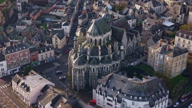 Basilica of Notre Dame of Miracles, revealing the surrounding cityscape of Mayenne, France. Aerial drone orbiting