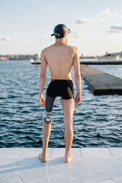 Amputee male looking at sea while standing on promenade during sunny day