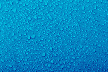 Close-up view of water droplets on a blue surface during a humid day