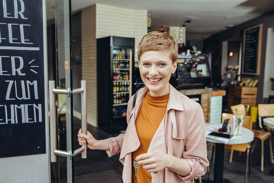Female cafe owner unlocking the door in the morning