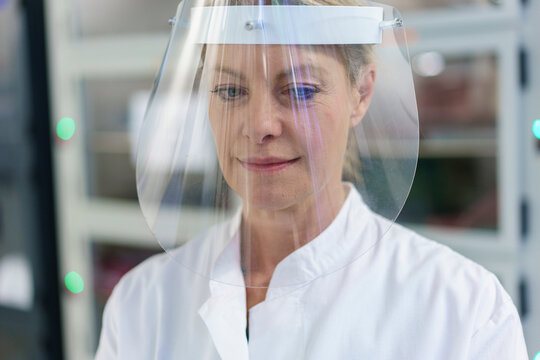 Close-up of mature female scientist wearing protective face shield at laboratory