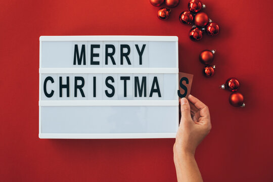 Woman's hands adding letter at 'Merry Christmas' sign