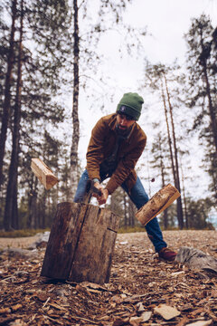 Young man chopping woog in the forest