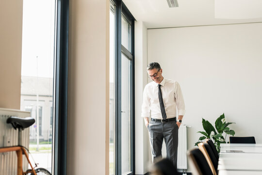 Laughing businessman standing in conference room