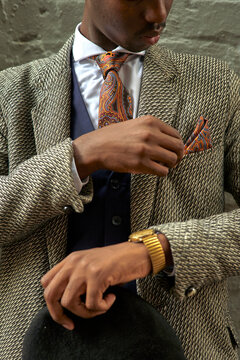 Stylish businessman holding a beret and checking his pocket square