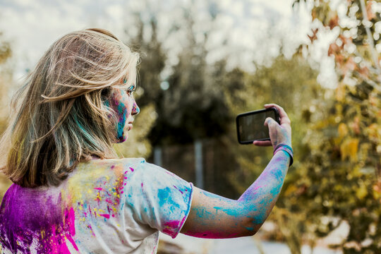 Gir Holi powder colours in her face, taking selfie, Germany