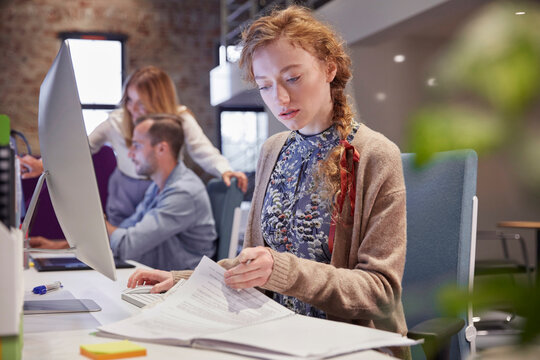 Young woman working in modern creative office, usine laptop
