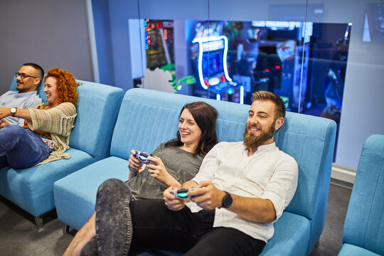 Happy friends playing and having fun in an amusement arcade