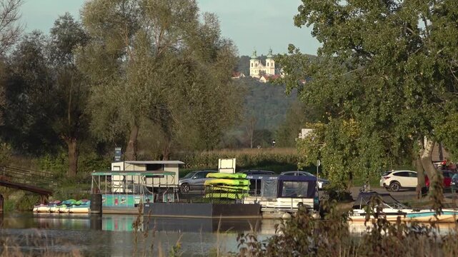 Small ferry harbor at the river Vistula leading to the Benedictine Abbey, and a monastery in background