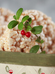 Close up of lingonberry (Vaccinium vitis-idaea) branch with red berries on rice cakes, healthy natural snack concept.