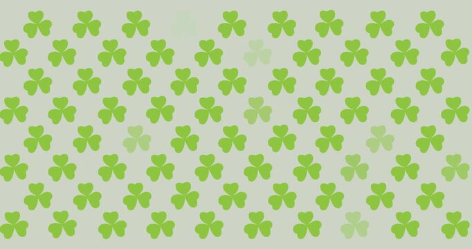 Digital animation of multiple clover leaves flickering against grey background