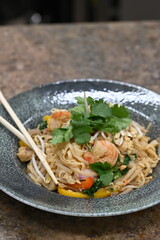 Fried rice noodles with shrimp, freshly prepared and served as a flavorful Asian dish. Colorful and appetizing meal presentation ideal for culinary, restaurant, and food background projects