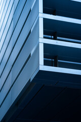 Obraz premium Modern architectural facade featuring geometric shapes and parallel lines, creating an abstract and minimalist pattern with a contemporary blue aesthetic