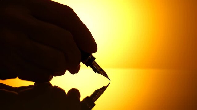 Silhouette of hand holding fountain pen
