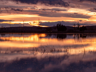 Fototapeta premium Sunset over the pool in Loreto, Huesca with golden reflections and colorful sky. Ideal image for tourism, summer and relaxation concepts in Spain.