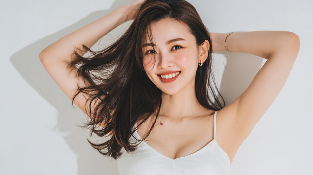 女性が白背景で髪を払って笑う