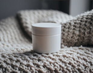 Blank white cosmetic jar mockup on soft knitted wool blanket