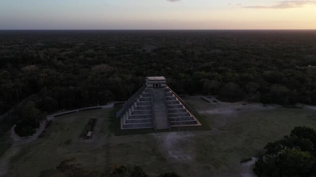 Aerial view of the majestic Chichen Itza pyramid standing tall against the backdrop of the Yucatan jungle, bathed in the warm glow of the setting sun, Chichen-Itza, Yucatan, Mexico.