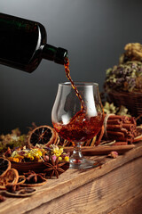 Herbal balm or tincture is poured from a vintage bottle into a glass.