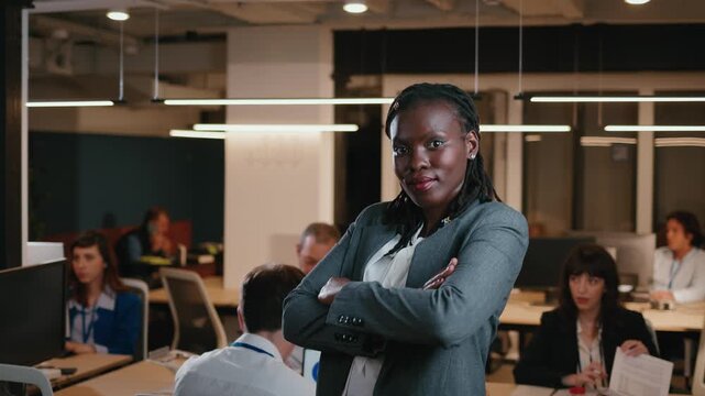 Confident african american businesswoman posing in a busy office
