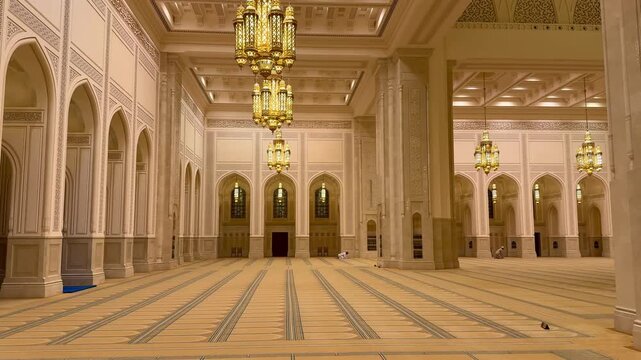 Sultan Qaboos Mosque in Nizwa featuring elegant Islamic architecture and illuminated minarets at night.