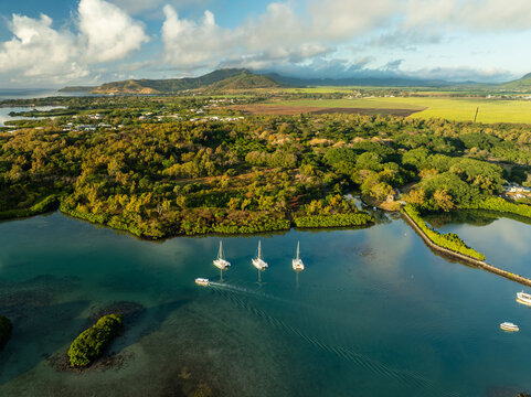 Aerial view of boats sailing on the turquoise waters past the lush green landscape, Shangri La, Trou d'Eau Douce, Mauritius.