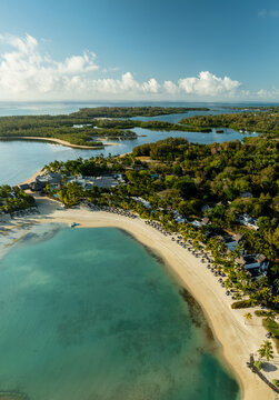 Aerial view of the sun-kissed beach meets the turquoise waters, fringed by lush greenery and tranquil lagoons, Shangri La, Trou d'Eau Douce, Mauritius.