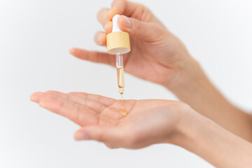 スキンケアプロセス。美容液を手元に出している女性の手元。