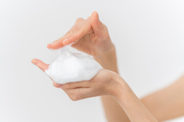 スキンケアプロセス。洗顔フォームの泡を手にのせている手元。